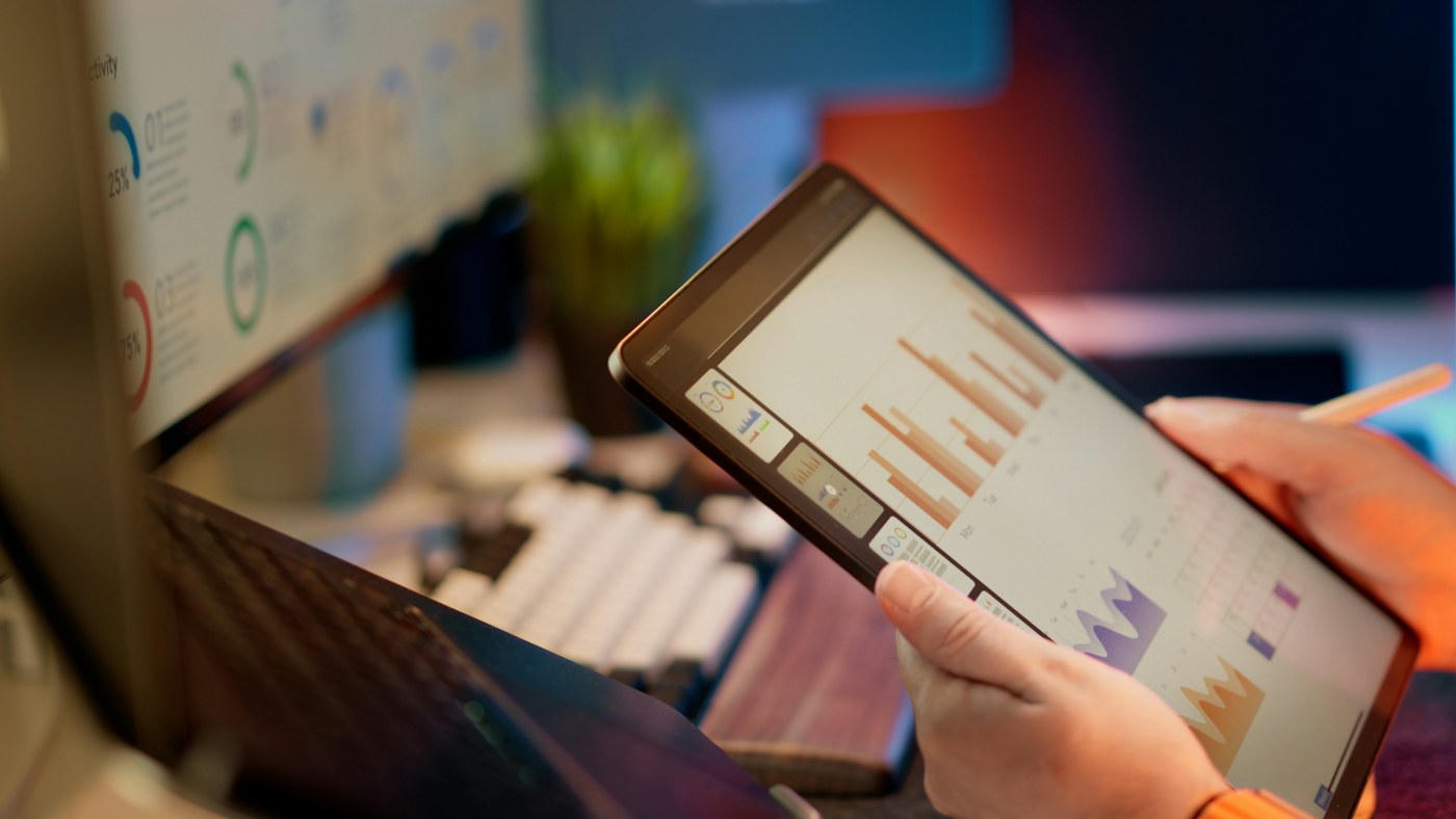 Person reviewing charts and data on a tablet