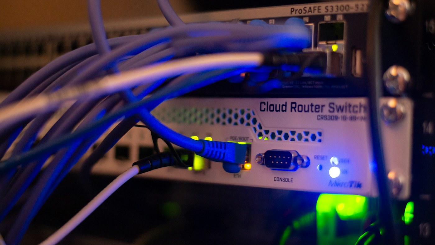 Blue network cables connected to a router and switch