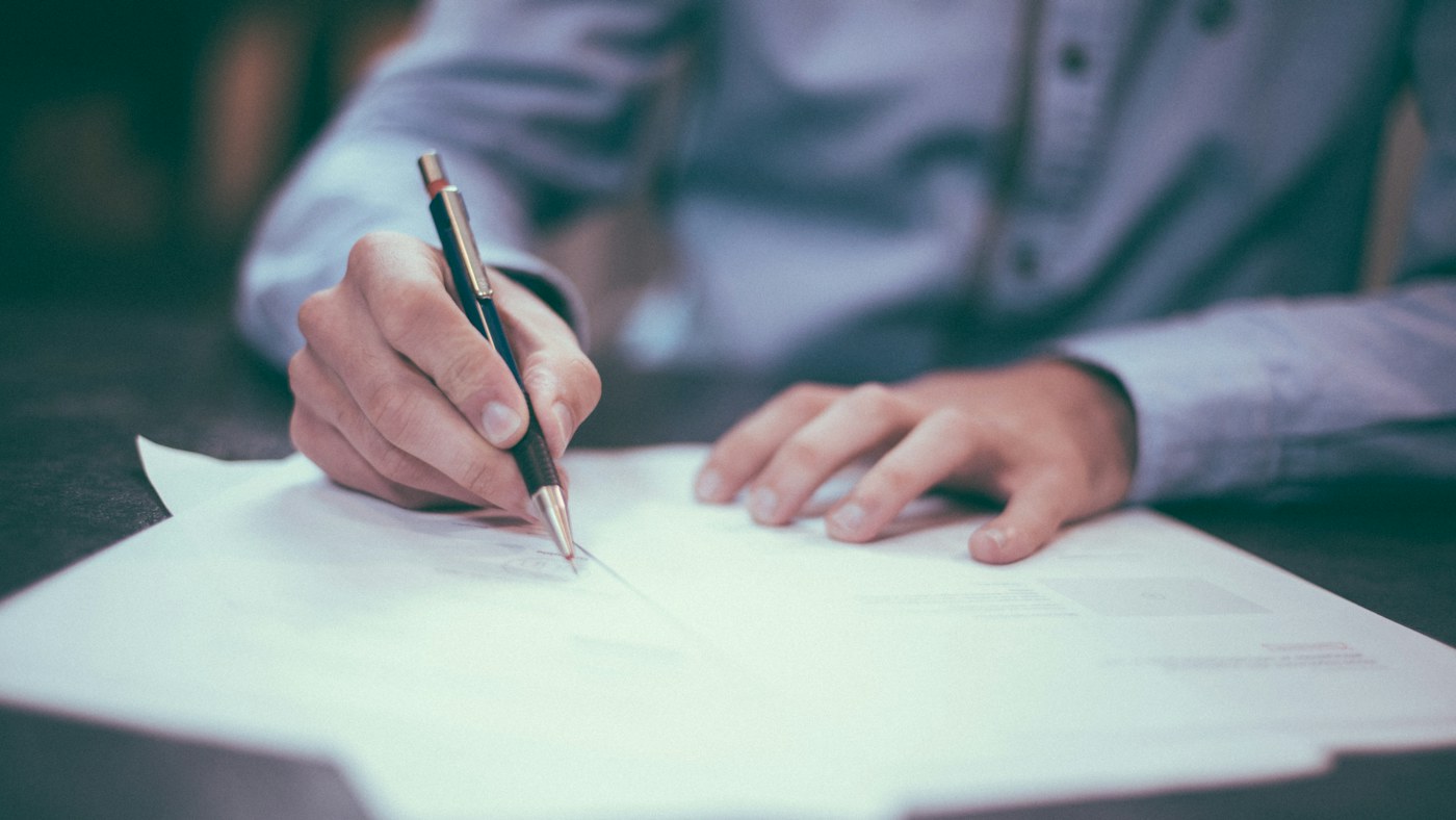 Person reviewing and writing on a business report