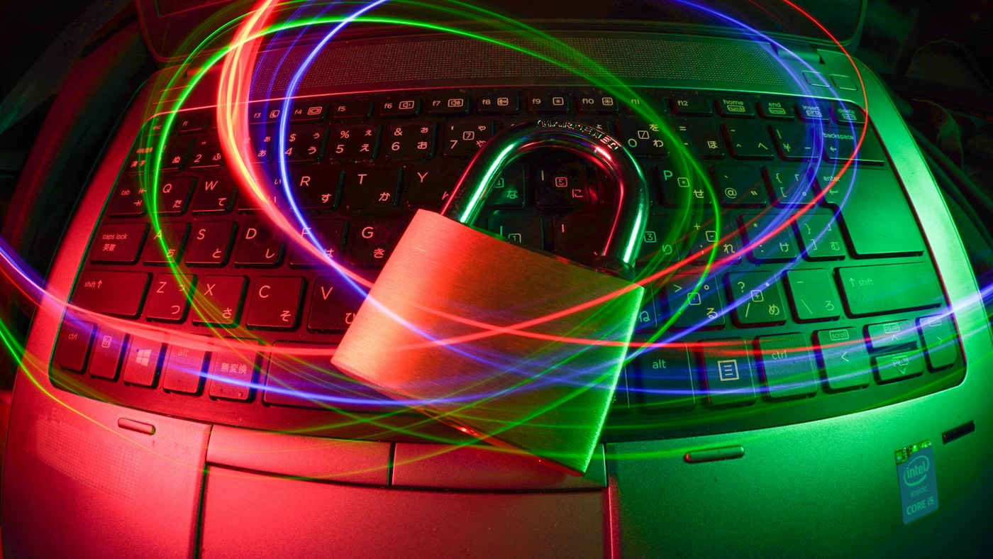 Padlock on a laptop surrounded by colored light trails