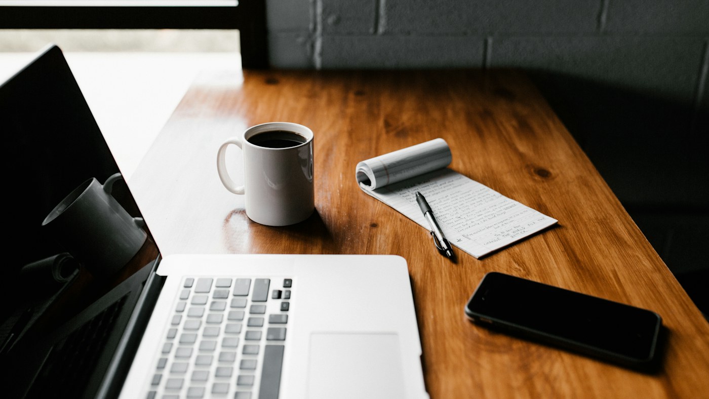 Laptop and smartphone on a wooden work desk